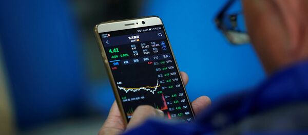 An investor checks stock information on a mobile phone at a brokerage house in Shanghai - 俄罗斯卫星通讯社