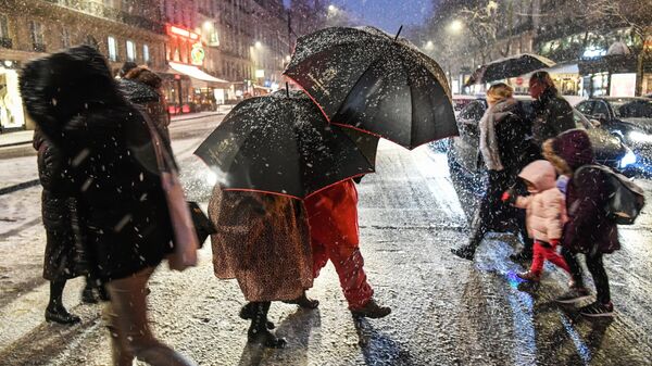Прохожие на пешеходном переходе во время снегопада в Париже - 俄罗斯卫星通讯社