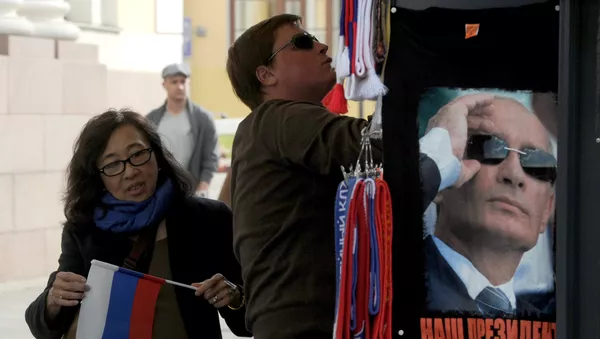 Chinese tourist holds Russian flag near a gift kiosk in central St. Petersburg - 俄羅斯衛星通訊社