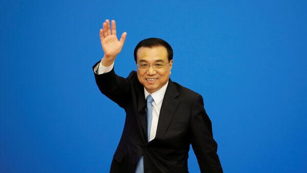 Chinese Premier Li Keqiang waves as he leaves the news conference following the closing session of the National People's Congress - 俄羅斯衛星通訊社