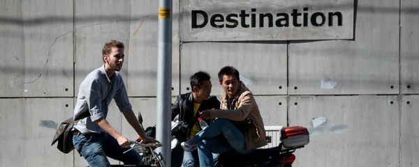 A foreigner cycles past two Chinese men outside a club in Beijing A foreigner cycles past two Chinese men outside a club in Beijing - 俄罗斯卫星通讯社