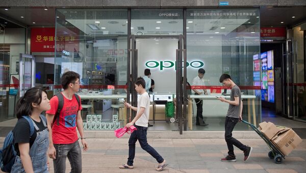 People walk in front of an Oppo shop in Shenzhen - 俄罗斯卫星通讯社