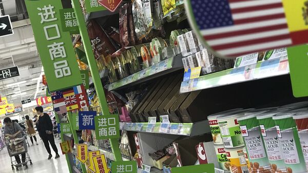 Women push a shopping cart near nuts and sweets imported from the United States and other countries displayed on a section selling imported foods at a supermarket in Beijing - 俄羅斯衛星通訊社