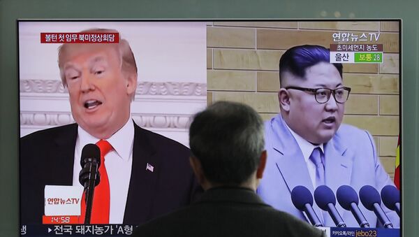 A man watches a TV screen showing file footages of U.S. President Donald Trump, left, and North Korean leader Kim Jong Un, right, during a news program at the Seoul Railway Station - 俄罗斯卫星通讯社