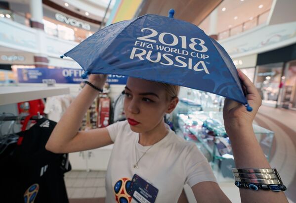 一名拿傘的女孩正在逛世界杯官方紀念品和服飾商店。 - 俄羅斯衛星通訊社