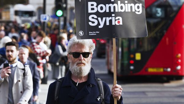 Мужчина держит плакат, призывающей не бомбить Сирию, на акции протеста против ударов по Сирии в Лондоне - 俄罗斯卫星通讯社