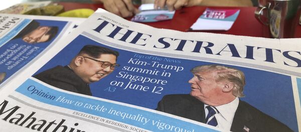 A news vendor counts her money near a stack of newspapers with a photo of U.S. President Donald Trump, right, and North Korea's leader Kim Jong Un on its front page - 俄罗斯卫星通讯社