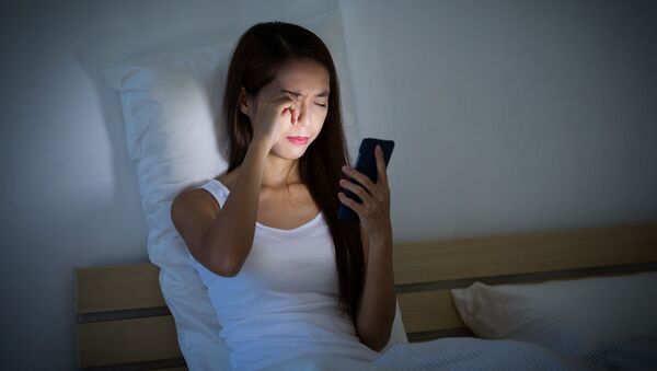 Девушка с мобильным телефоном в руках в постели - 俄羅斯衛星通訊社