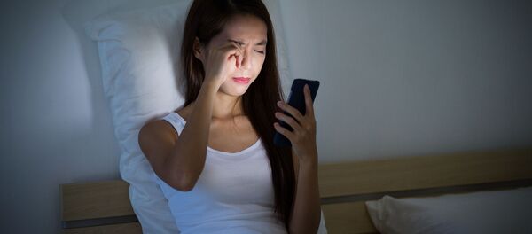 Девушка с мобильным телефоном в руках в постели - 俄羅斯衛星通訊社