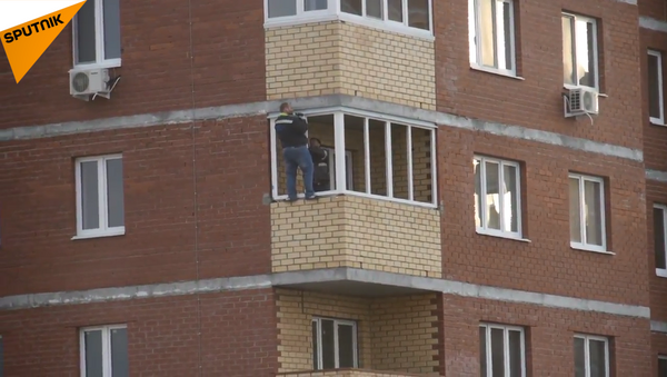 勇敢的工人在12楼阳台外装窗户 - 俄罗斯卫星通讯社