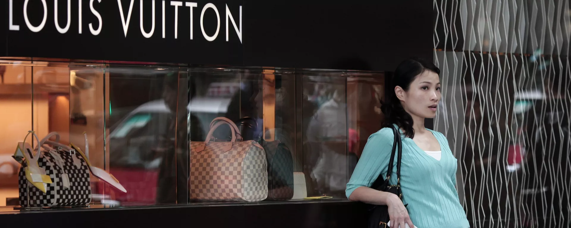 A Chinese woman leaning on a Louis Vuitton shop display window - 俄羅斯衛星通訊社, 1920, 22.01.2019