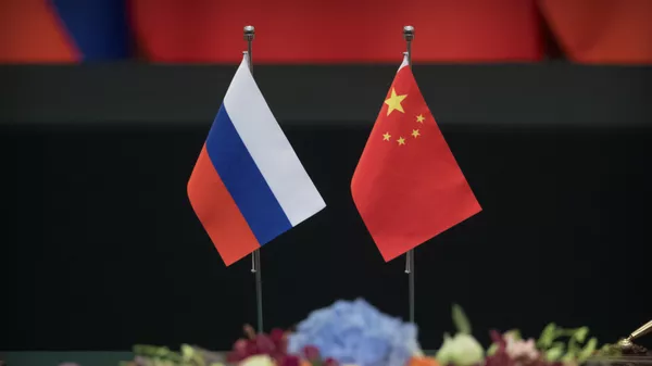 Russian, left, and Chinese flags sit on a table before a signing ceremony at the Great Hall of the People in Beijing - 俄罗斯卫星通讯社