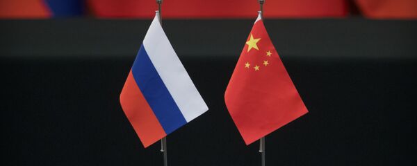 Russian, left, and Chinese flags sit on a table before a signing ceremony at the Great Hall of the People in Beijing - 俄罗斯卫星通讯社