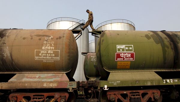 A worker walking atop a tanker wagon to check the freight level at an oil terminal on outskirts of Kolkata - 俄罗斯卫星通讯社