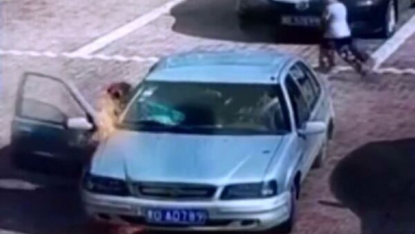 一中国男子试图吹灭一辆燃烧的轿车 - 俄罗斯卫星通讯社