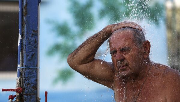 A man takes a shower at a beach of Alimos suburb in Athens, on Saturday, July 1, 2017. A summer heatwave has hit Greece, with temperatures reaching a high of 43 degrees Celsius (111 Fahrenheit) in Athens, and is expected to last over the weekend. - 俄羅斯衛星通訊社