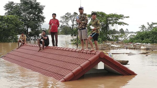 Селяне спасаются от наводнения, вызванного прорывом дамбы, на крыше дома в юго-восточной лаосской провинции Аттапы - 俄罗斯卫星通讯社