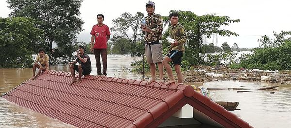 Селяне спасаются от наводнения, вызванного прорывом дамбы, на крыше дома в юго-восточной лаосской провинции Аттапы - 俄羅斯衛星通訊社