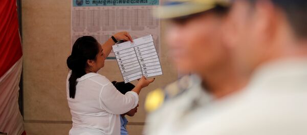 Police provide security at a polling station as an official counts ballots in Cambodia's general election, at a polling station in Phnom Penh Police provide security at a polling station as an official counts ballots in Cambodia's general election, at a polling station in Phnom Penh - 俄罗斯卫星通讯社