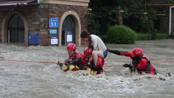 Firefighters rescue a stranded woman on a flooded street, following heavy rainfall in Chengdu - 俄羅斯衛星通訊社