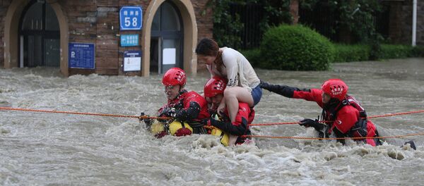 Firefighters rescue a stranded woman on a flooded street, following heavy rainfall in Chengdu - 俄罗斯卫星通讯社