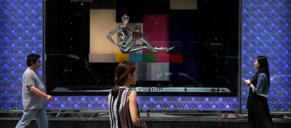 Pedestrians walk past a high end fashion store - 俄罗斯卫星通讯社