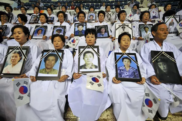 朝鮮人手捧在紀念從日本殖民統治下解放66週年的反日遊行中死去的家庭成員肖像。 朝鮮人手捧在紀念從日本殖民統治下解放66週年的反日遊行中死去的家庭成員肖像。 - 俄羅斯衛星通訊社