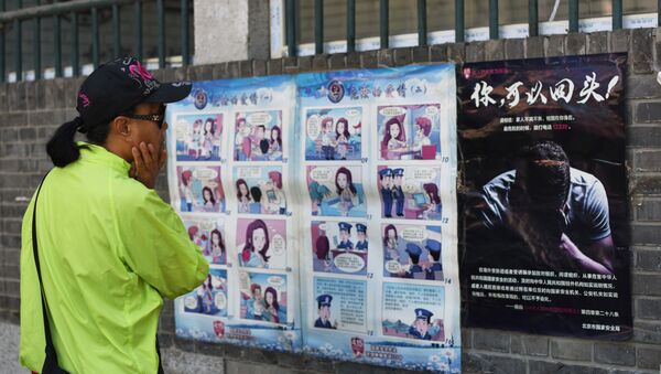A woman looks at a propaganda cartoon warning local residents about foreign spies, in an alley in Beijing - 俄罗斯卫星通讯社