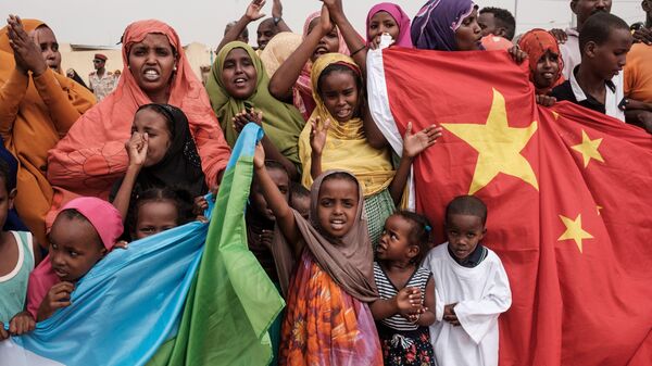 People hold Chinese and Djiboutian national flags  - 俄罗斯卫星通讯社