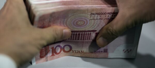 A bank employee counts out 100 yuan notes at a bank in Shanghai - 俄罗斯卫星通讯社