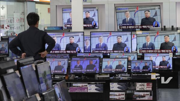 Мужчина смотрит трансляцию официальной церемони приветствия лидеров Северной и Южной Корей Ким Чен Ына и Мун Чжэ Ина в Пхеньянском аэропорту Сунан - 俄羅斯衛星通訊社