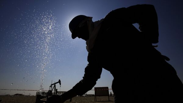 Нефтяник корректирует клапан, выпускающий распыление воды при работе на нефтепроводах на пустынных нефтяных месторождениях - 俄羅斯衛星通訊社
