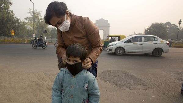 Мать надевает сыну маску, чтобы защитить легкие от смога в Нью-Дели, Индия - 俄罗斯卫星通讯社