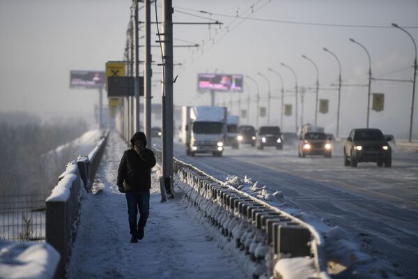 一名男子步行在新西伯利亞市橫跨鄂畢河的德米特羅夫斯克橋上 - 俄羅斯衛星通訊社