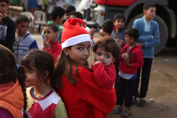 贝鲁特发放礼物时带着一名叙利亚孩子的黎巴嫩女孩。 - 俄罗斯卫星通讯社