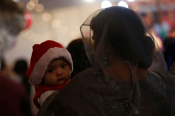 巴基斯坦庆祝圣诞节期间教堂里一名带着孩子的女子。 - 俄罗斯卫星通讯社