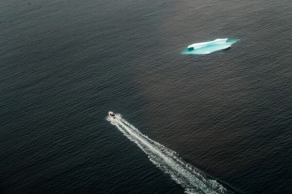 一艘小艇駛過塔西拉克鎮旁的開闊海域上的冰山，格陵蘭島 - 俄羅斯衛星通訊社