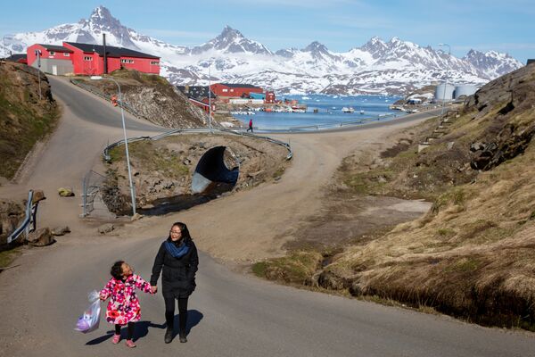 女人和孩子沿著塔西拉克鎮的街道散步，格陵蘭島 - 俄羅斯衛星通訊社
