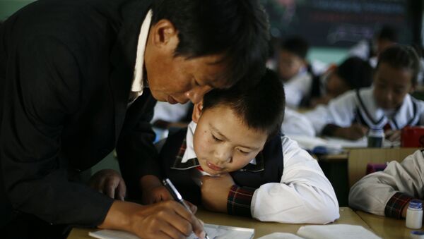 Учитель помогает ученику с заданием в Китае. - 俄羅斯衛星通訊社