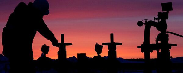 A worker checks the valve of an oil pipe at an oil field - 俄罗斯卫星通讯社