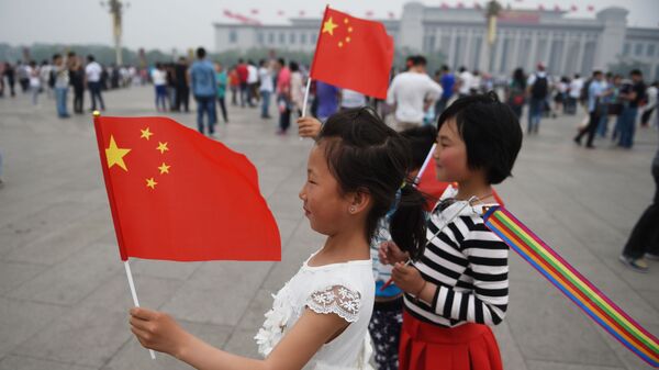 Дети позируют с китайскими флагами на площади Тяньаньмэнь в Пекине - 俄罗斯卫星通讯社