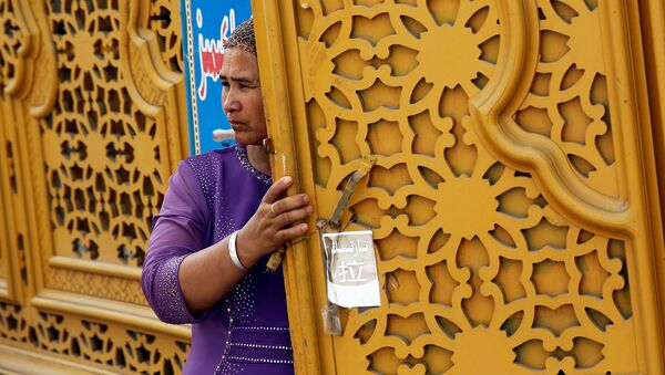 Женщина у двери в Старом городе в Кашгаре, Синьцзян-Уйгурский автономный район, Китай - 俄羅斯衛星通訊社