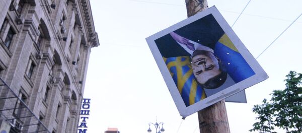 Перевернутый портрет отстраненного от должности президента Украины Виктора Януковича на площади Независимости в Киеве - 俄罗斯卫星通讯社