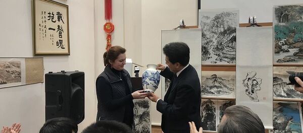 由俄罗斯女画家安娜∙多琴科把自己绘制的瓷器赠给出席展览会的中国驻俄罗斯大使 - 俄罗斯卫星通讯社