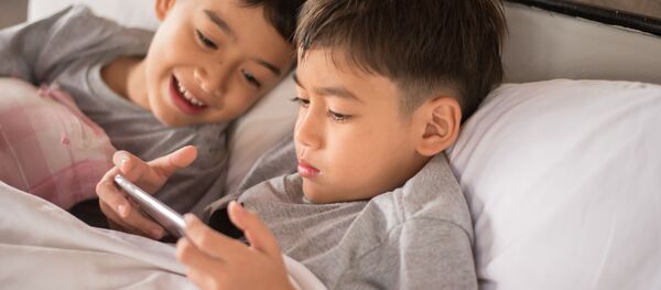 Мальчики играют в видеоигры на смартфоне - 俄罗斯卫星通讯社