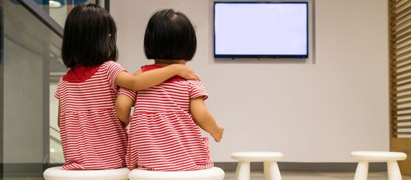 Две девочки смотрят телевизор - 俄罗斯卫星通讯社