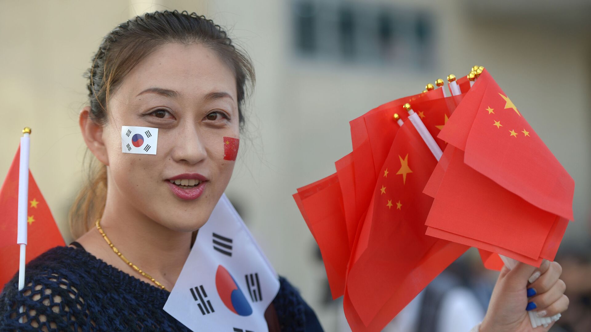Девушка держит китайские и южнокорейские флаги около главного стадиона в Инчхон - 俄罗斯卫星通讯社, 1920, 13.12.2021