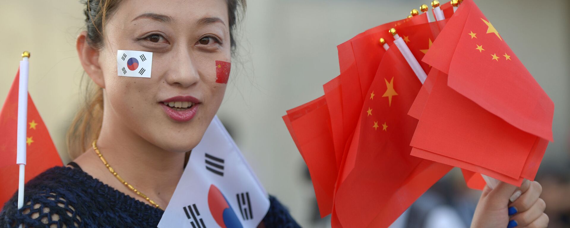 Девушка держит китайские и южнокорейские флаги около главного стадиона в Инчхон - 俄罗斯卫星通讯社, 1920, 13.12.2021