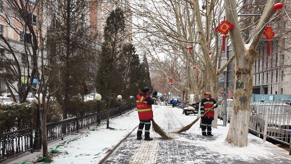 Сотрудники коммунальных служб во время уборки снега на одной из улиц Пекина.  - 俄罗斯卫星通讯社