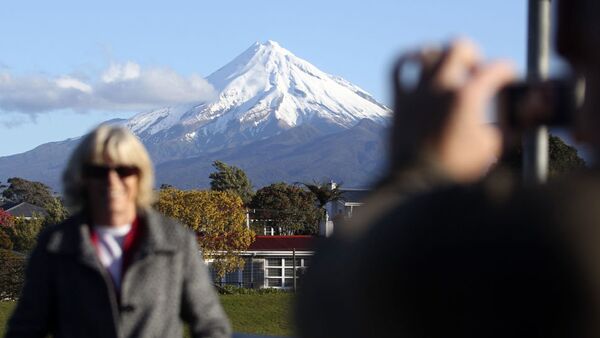 Туристка фотографируется на фоне Вулкана Таранаки. Новая Зеландия - 俄罗斯卫星通讯社